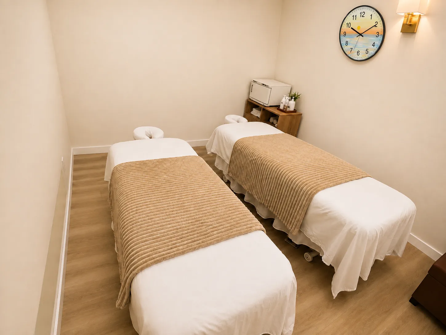 Twin massage tables made up with warm blankets in a bright treatment room at Harbor Wellness Massage in San Carlos
